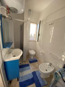 a bathroom with a sink and a toilet at Casa vacanze Kastalia - Blu in Ragusa