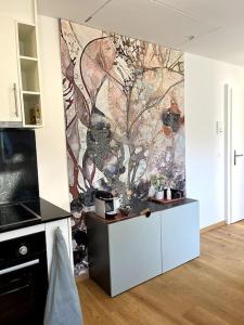 a kitchen with a painting on the wall at penthouse-studio centrally located in Zurich in Zürich