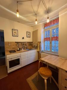 eine Küche mit einem Holztisch und einer Arbeitsplatte in der Unterkunft L'ARCADE in Louhans