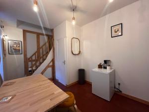 Zimmer mit einem Holztisch und einer Treppe in der Unterkunft L'ARCADE in Louhans