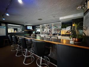 a bar with a row of bar stools at Hôtel Les Mouettes in Sept-Îles