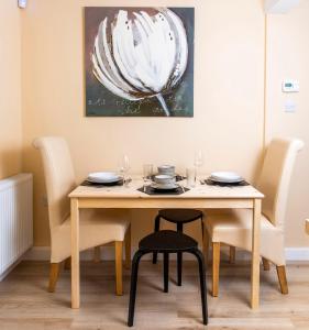 a dining room table and chairs with a painting on the wall at The Apartment at No.12 in Lochwinnoch