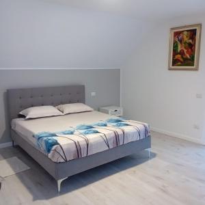ein Bett in einem Schlafzimmer mit einer weißen Wand in der Unterkunft Casa Mont Blanc Cavnic in Cavnic