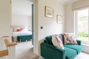 a living room with a green couch and a bed at Near Major Attractions Comfortable TV in Bath