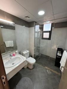 La salle de bains est pourvue de toilettes, d'un lavabo et d'une douche. dans l'établissement Sharja 1302, à Charjah