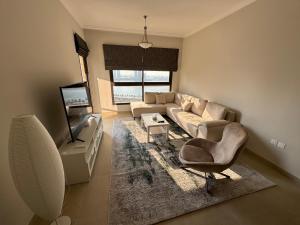 a living room with a couch and a television at Sharja 1302 in Sharjah