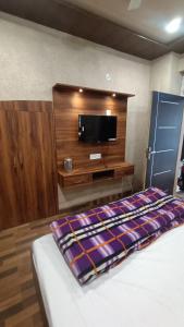 a bedroom with a bed and a flat screen tv at Priya Hotel in Faizābād