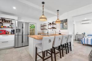 a kitchen with a large island with bar stools at Private Fort Lauderdale cottage in Fort Lauderdale