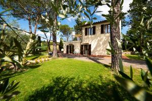 een huis met een tuin met gras en bomen bij Il Pucchio in Certaldo