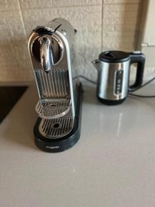 a toaster sitting on a counter next to a coffee pot at Studio dans le quartier luxe in Neuilly-sur-Seine