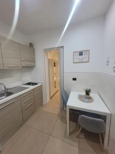 a kitchen with a table and a sink and a table and chairs at House del Levante Locazione turistica in Bari