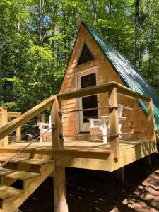 eine große Holzhütte mit grünem Dach in der Unterkunft Cabin in Maine Woods-The Bogey in North Lovell