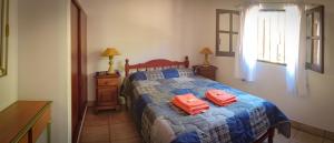Un dormitorio con una cama con dos cajas de naranja. en Cabañas Kurmi en Humahuaca