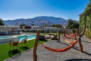 une cour avec un hamac et une piscine dans l'établissement Sunny Vista Pool And Spa Home With Mountain Views, à Palm Springs