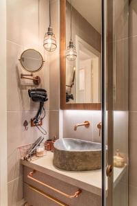 een badkamer met een wastafel en een spiegel bij Central Kifissia BLέ LÍMε ÁPPεROL Malomar Homing in Athene