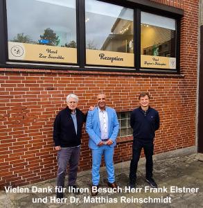 un grupo de tres hombres parados frente a un edificio de ladrillo en Hotel Neptuns Ankerplatz, en Cuxhaven