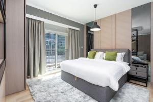 um quarto com uma grande cama branca e uma janela em Downtown Dubai - CityApartmentStay em Dubai