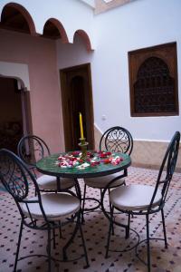 einen Tisch und Stühle mit einer Kerze drauf in der Unterkunft RIAD LAICHI in Marrakesch