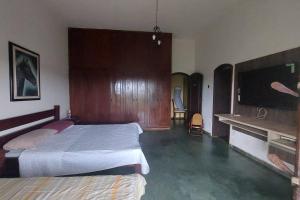 1 Schlafzimmer mit 2 Betten und einem Flachbild-TV in der Unterkunft Casa de campo Sede de Fazenda - MT in Nossa Senhora do Livramento