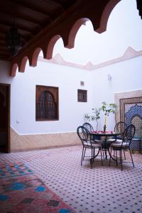 eine Terrasse mit einem Tisch und Stühlen in einem Zimmer in der Unterkunft RIAD LAICHI in Marrakesch