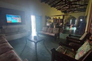 a living room with a couch and a tv at Casa de campo Sede de Fazenda - MT in Nossa Senhora do Livramento