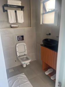 een kleine badkamer met een toilet en een wastafel bij Lake Elementaita Manor in Gilgil
