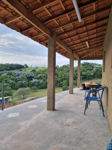 a patio with a table and a view of the countryside at O Zóio da cobra é verde in Bragança Paulista
