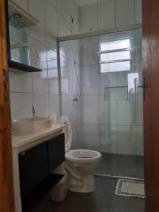 a bathroom with a toilet and a sink and a shower at O Zóio da cobra é verde in Bragança Paulista