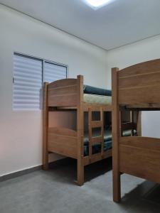 two bunk beds in a room with a window at O Zóio da cobra é verde in Bragança Paulista