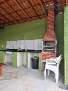 a kitchen with a stove and a table and a chair at O Zóio da cobra é verde in Bragança Paulista