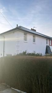 a white house with a yard in front of it at A modern home close to city centre with parking in Killingbeck