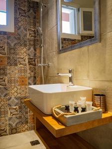 ein Badezimmer mit einem weißen Waschbecken und einem Spiegel in der Unterkunft Dina Apartments Argostoli in Argostoli