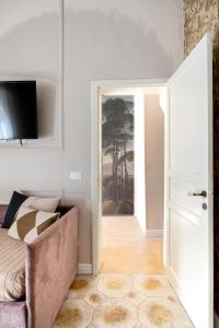 ein Wohnzimmer mit einem Sofa und einer offenen Tür in der Unterkunft Ziolì in Noto