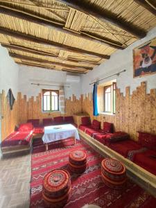 a room with a bed and some chairs and a rug at Casa Mona in Merzouga