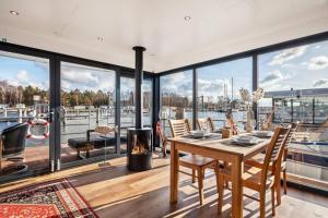 a dining room with a table and a fire place at Hausboot Chalet am Meer - LP8 in Peenemünde