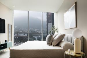 a bedroom with a bed and a large window at Sinfonía de serenidad y estilo, 3 min de San Pedro in Monterrey