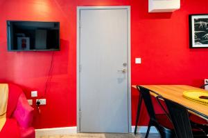 een rode kamer met een witte deur en een rode muur bij Cardiff Getaway - City Center - Free Parking in Cardiff