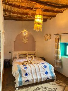 a bedroom with a bed with a wooden head board at Casa Mona in Merzouga