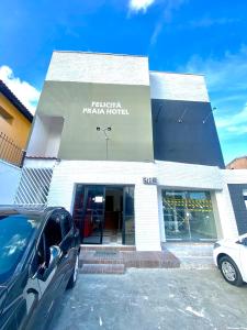 un edificio con un'auto parcheggiata di fronte di Felicità Praia Hotel a Fortaleza