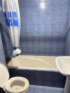 een badkamer met een toilet, een bad en een wastafel bij Rosas287 in Puerto Iguazú