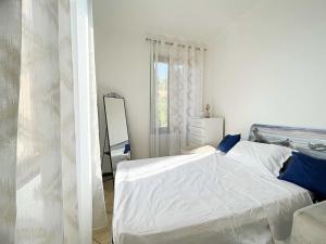 biała sypialnia z łóżkiem i lustrem w obiekcie Appartamento confortevole con terrazza w Como