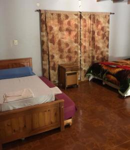 een slaapkamer met 2 bedden en een raam met gordijnen bij Rosas287 in Puerto Iguazú