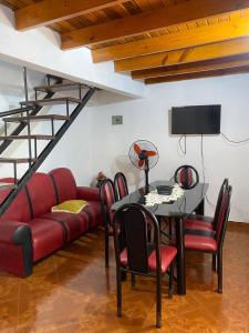 een woonkamer met een rode bank en een tafel bij Rosas287 in Puerto Iguazú