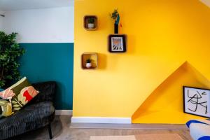 een woonkamer met een gele muur en een bank bij Cardiff Getaway - City Center - Free Parking in Cardiff