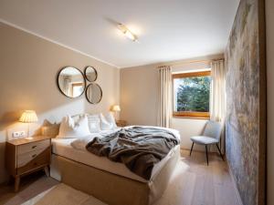 ein Schlafzimmer mit einem Bett, einem Stuhl und einem Fenster in der Unterkunft Ferienwohnung Lentner in Maurach