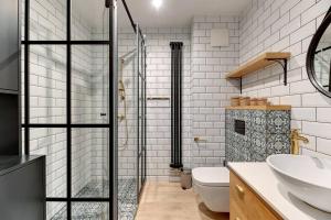 a bathroom with a shower and a toilet and a sink at Rezydencja Wintera 3 by Grand Apartements in Gdańsk