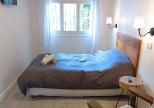 埃爾博爾松的住宿－Departamento Céntrico 3，一间卧室配有一张带蓝色床单的床和一扇窗户。