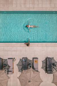 uma pessoa a nadar numa piscina em OPSIS Suites em Limenaria