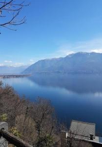 Blick auf einen großen Wasserkörper mit Bergen in der Unterkunft "Pipistrello" 3 Zimmer grosses bezauberndes freistehendes Tessiner Ferienhaus mit unglaublich viel Charme in Ronco sopra Ascona