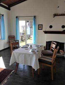 ein Esszimmer mit einem Tisch, Stühlen und einem Kamin in der Unterkunft "Pipistrello" 3 Zimmer grosses bezauberndes freistehendes Tessiner Ferienhaus mit unglaublich viel Charme in Ronco sopra Ascona